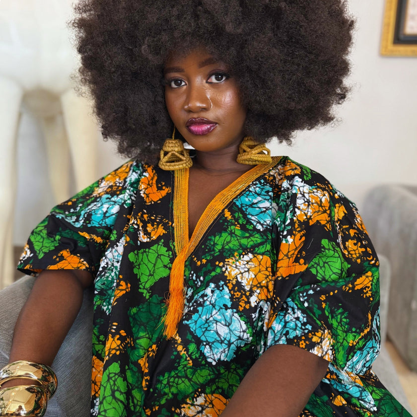 Close front view showing neckline details: Close front view of the Jọkẹ́ Bubu Dress focusing on the hand-embroidered V-neckline with intricate orange embroidery and tassel details, highlighting the craftsmanship and unique design.