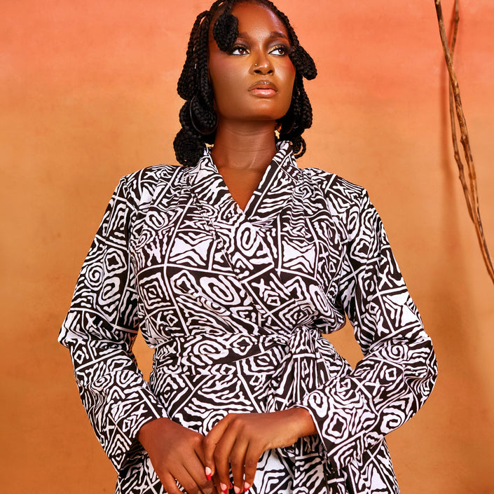 The Ahoɔfɛ dress highlights a flattering crossover bust, secure wrap tie closure, and structured shoulder pads for a polished, tailored silhouette.