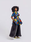 A model wearing the two-piece set featuring a multi-colored swirl print peplum top and a sheer, unlined black organdy maxi skirt