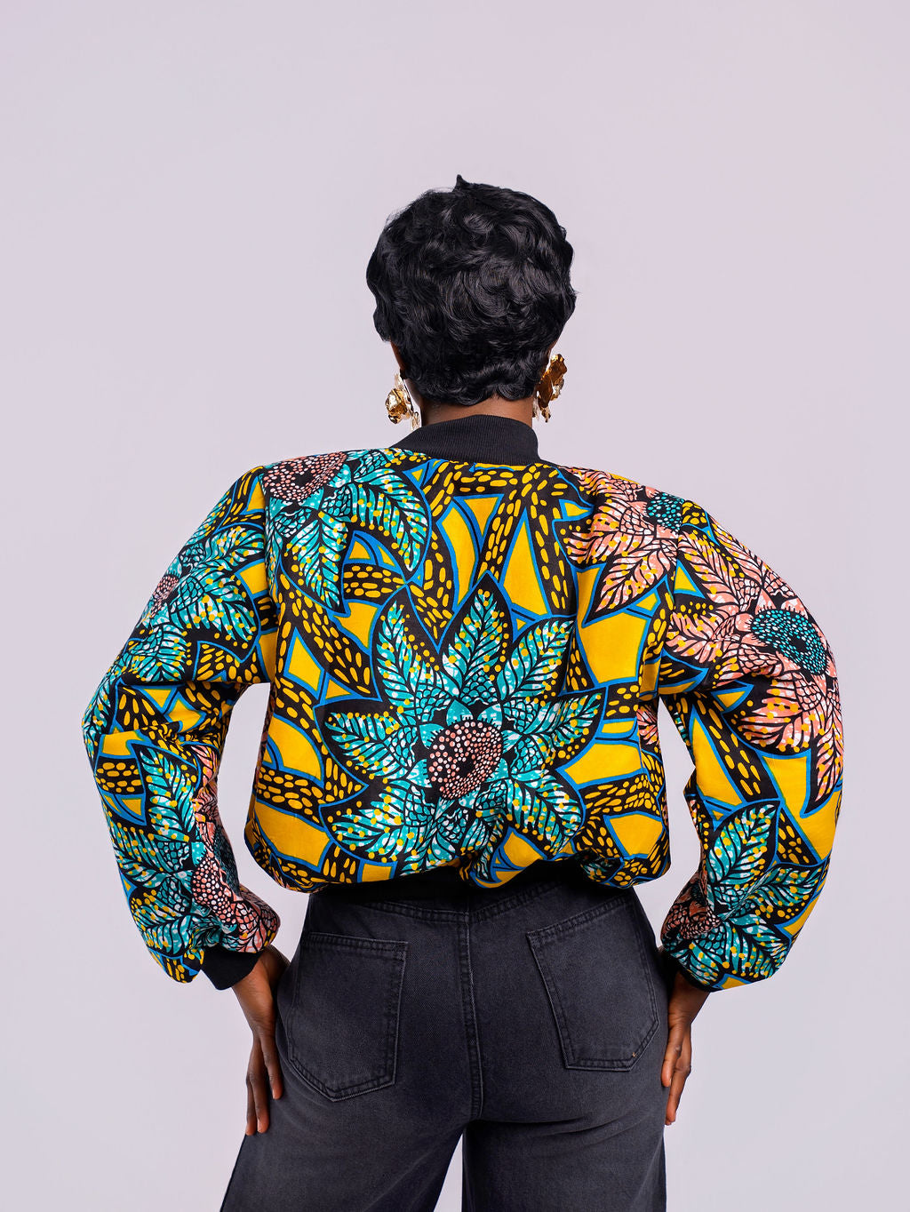 Back view of the Sunflower Bomber Jacket highlighting the large, symmetrical floral print, ribbed neckline and structured fit.