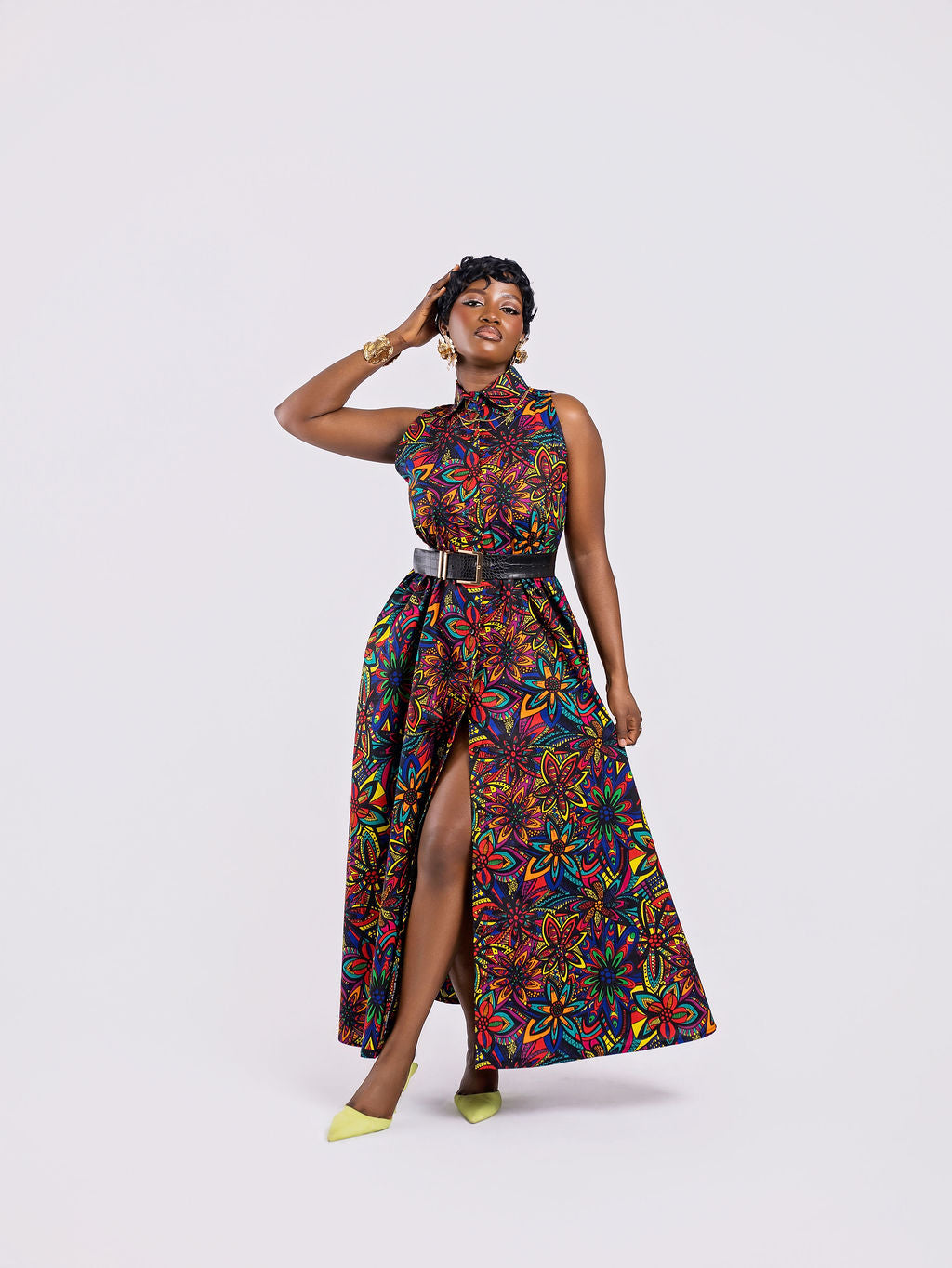 Full-length front view of a woman wearing the Amazin Apparels Kaleidoscope Gown, showing the function of the dress when buttoned half way , highlighting functional design. in a vibrant floral African print.