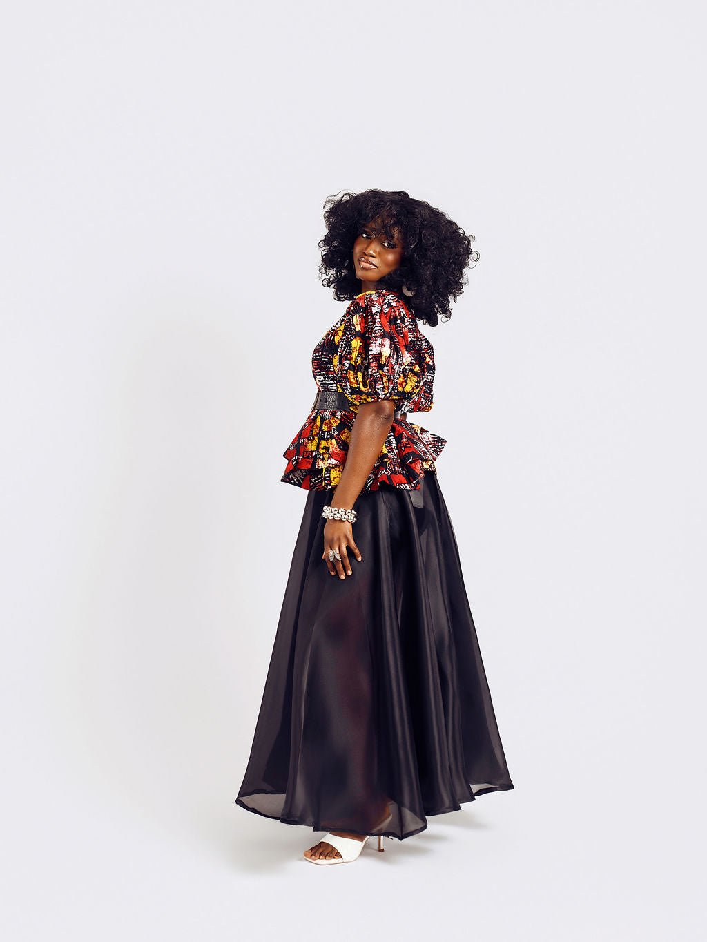 Side-view of a model wearing the Seyi Ankara Peplum Top 
