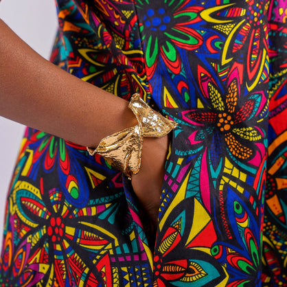A hand tucked into the hidden side-seam pocket of the Kaleidoscope floral maxi dress, highlighting functional design