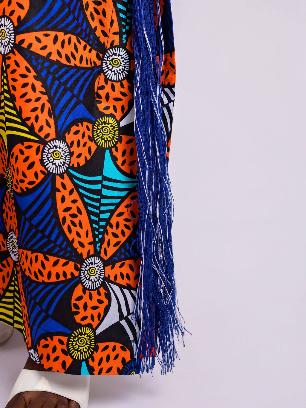 Close-up of the shredded Aso Oke fringe highlighting the floor length