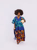 front view of a woman in the Amazin Apparels Aso Oke Fusion Gown, featuring a blue pinstripe top with v-neck, bold floral skirt, and floor-length shredded Aso Oke fringe on the sides coming from the waist division made of authentic textured Aso Oke fabric on a multi-patterned maxi dress.